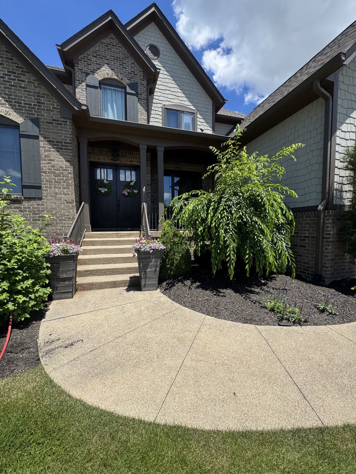 Brick home entrance with clean walkway and landscaping